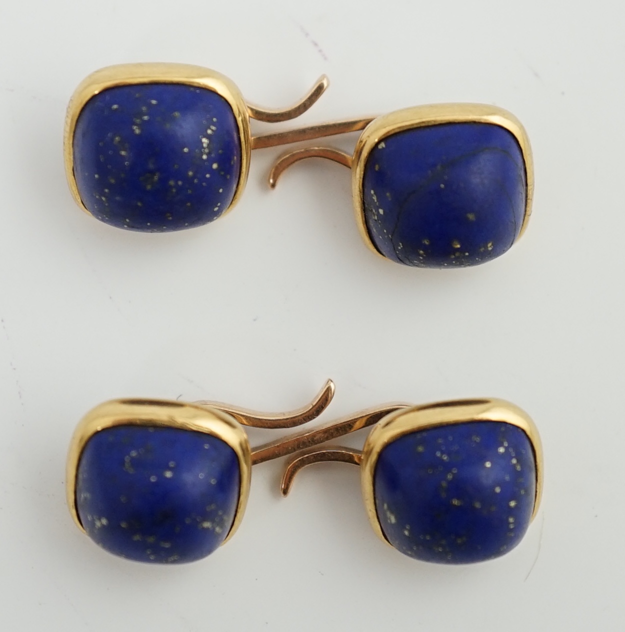 A pair of gold mounted cabochon lapis lazuli set cufflinks